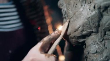 Bir kil heykeli pürüzsüz hale getirilirken