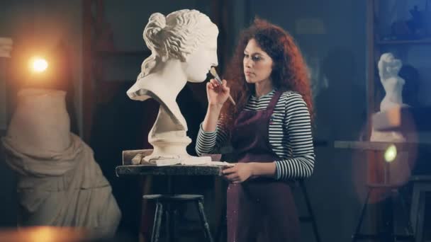 La escultora se encarga de un busto de yeso blanco. Inspiración, concepto de trabajo creativo. — Vídeo de stock