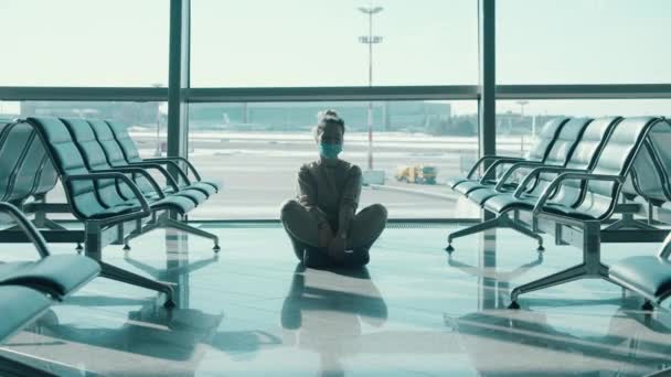 Леди в маске для лица начинает медитировать в аэропорту — стоковое видео