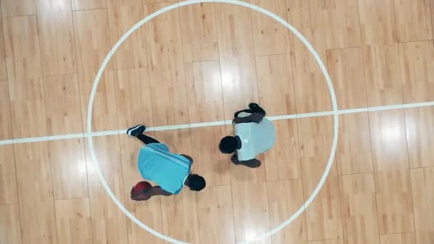 Dos jugadores de baloncesto están practicando en el gimnasio en una vista superior — Vídeos de Stock