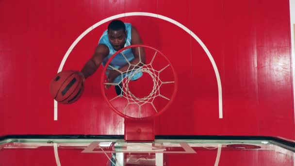 Vista superior de una canasta de gimnasio con una pelota lanzada en ella. Deportista profesional anotando un gol. — Vídeos de Stock