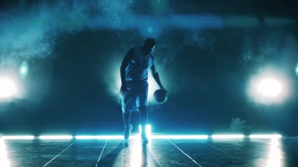 Erkek sporcu karanlıkta basketbol topuyla hokkabazlık yapıyor. — Stok video