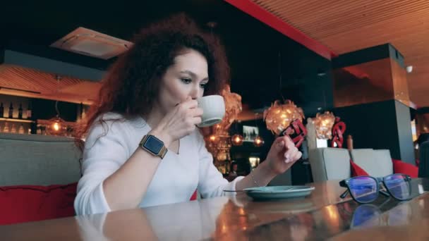 Een vrouw betaalt haar caférekening met haar slimme horloge — Stockvideo