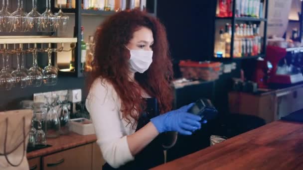Waitress in a face mask is using a credit card machine — Stock Video