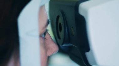 Bir kadın görme yeteneğini kontrol eden bir mekanizmaya bakıyor.