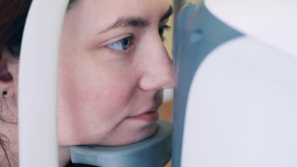 Μια γυναίκα χρησιμοποιεί μια ιατρική συσκευή για να ελέγξει την όρασή της. — Αρχείο Βίντεο