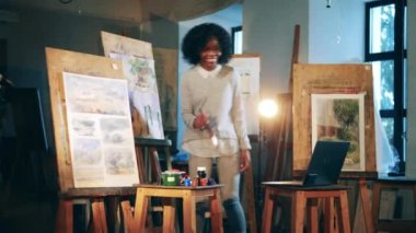 Afrikalı etnik kadın sanat okulunda bir video dersi veriyor.