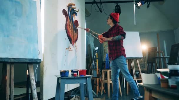 Un artista sta spruzzando il suo quadro con la vernice — Video Stock