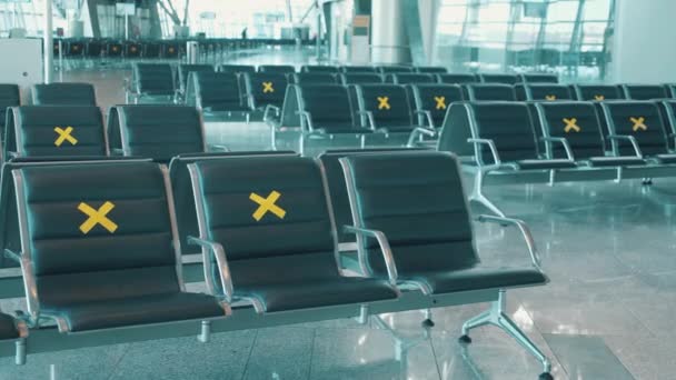 Seats in the airport hall marked unavailable due to pandemic — Stock Video