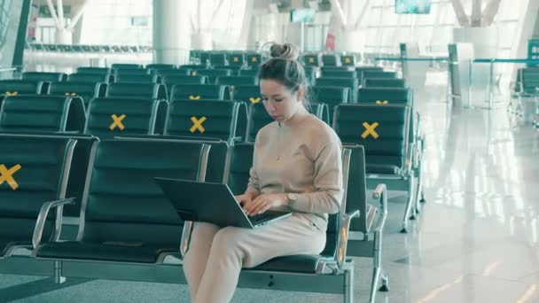 Uma mulher com um laptop na sala de embarque vazia — Vídeo de Stock