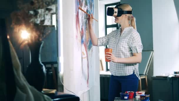 Wirtualna rzeczywistość, futurystyczna koncepcja sztuki. Uśmiechnięta dama w okularach VR tworzy kolorowy obraz — Wideo stockowe