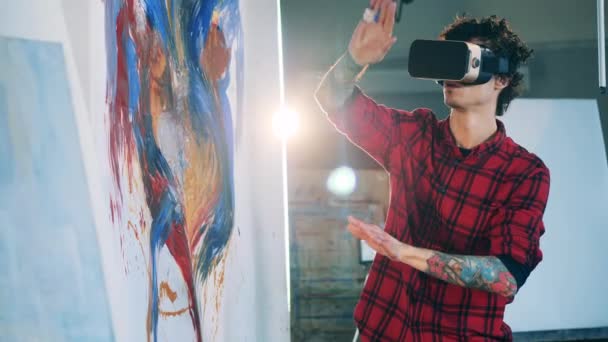 Virtuelle Realität, futuristisches Kunstkonzept. Männlicher Künstler schafft mit VR-Brille ein Gemälde — Stockvideo