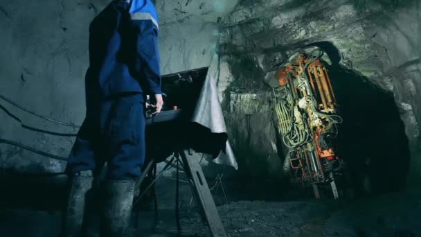 Промышленный рабочий управляет скучным механизмом в шахте — стоковое видео