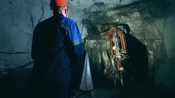 Mineiro está operando um mecanismo de perfuração para irrigar um túnel — Vídeo de Stock