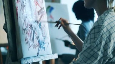 Bir bayan resim dersi sırasında çok renkli bir resim çiziyor.