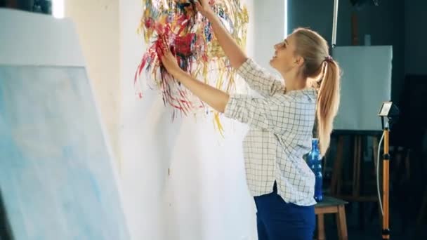 Lady pintor está criando um quadro multicolorido com as mãos nuas — Vídeo de Stock