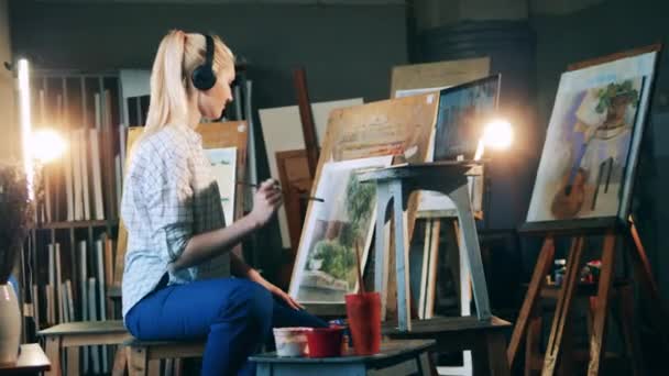 Blond dame heeft een internet les en schilderij — Stockvideo