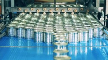 Fabrika taşıyıcısı, metal kutularla endüstriyel üretim hattı. Yeni mühürlenmiş teneke kutular naklediliyor.