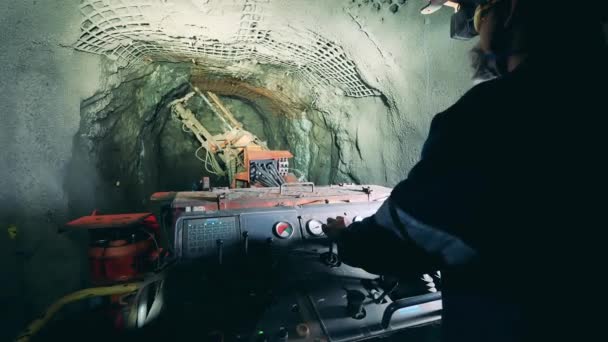 Trabajador industrial está utilizando un mecanismo aburrido para regar una mina — Vídeo de stock