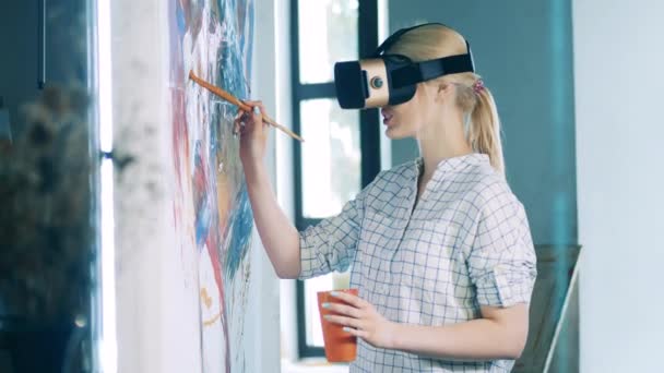 Blonde Dame mit VR-Brille lächelt beim Malen auf Leinwand — Stockvideo
