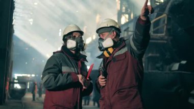 İki güvenlik uzmanı metalurji fabrikasında konuşuyorlar. Metalurji fabrikası konsepti.