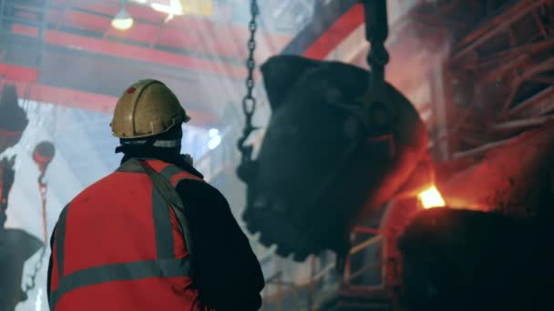 Il lavoratore dell'acciaio sta guardando il melting pot con metallo fuso. Concetto di metallurgia. Metallo fuso nella fabbrica metallurgica. — Video Stock