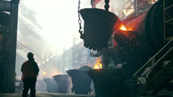 Conceito de fábrica metalúrgica. Trabalhador de aço está observando cobre derretido ficando transfundido. Steelmaker, metalúrgico, metalúrgico na fábrica metalúrgica. — Vídeo de Stock