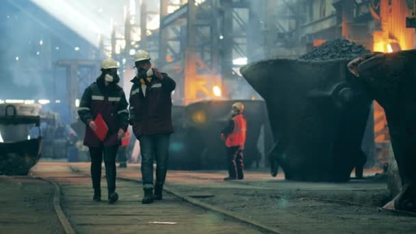 Stålarbetarna går längs fabrikens område. Koncept för metallverk. — Stockvideo