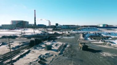 Makineler bir metalurji fabrikasının arazisinden geçiyor.