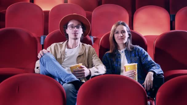 Un couple rit en regardant un film — Video