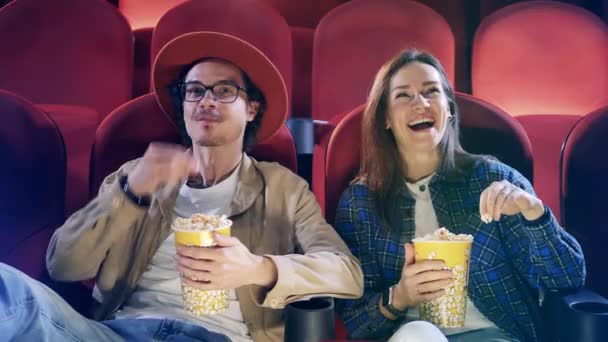 Young man and woman are laughing at the cinema — Stock Video