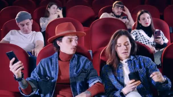 Az emberek unatkoznak, miközben filmet néznek a moziban. — Stock videók