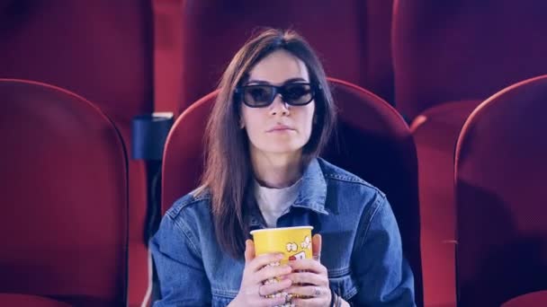 Egy hölgy megijed, miközben filmet néz a moziban. — Stock videók