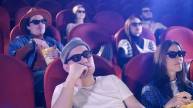Sinemada insanlar birbirlerine patlamış mısır fırlatıyor. Sinema, film, eğlence konsepti.