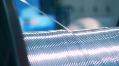 Bir makaradan kopan gümüş elektrik kablosunun yakın görüntüsü