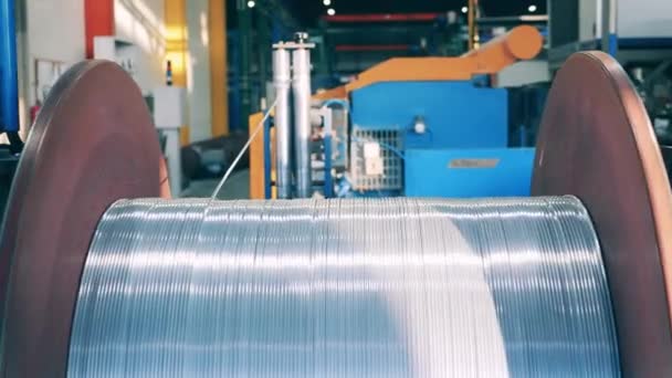 Grueso cable de plata que se desenrolla de un carrete de metal grande — Vídeos de Stock
