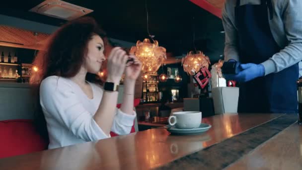 Женщина использует бесконтактные платежи в кафе во время пандемии — стоковое видео