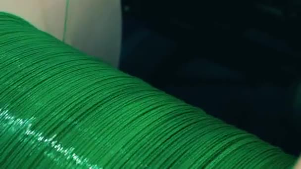 Green shiny wire winding to a spool in a close up — Stock Video