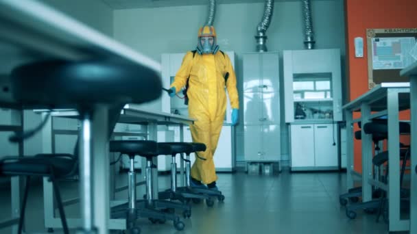 L'homme en danger désinfecte une salle de laboratoire. — Video