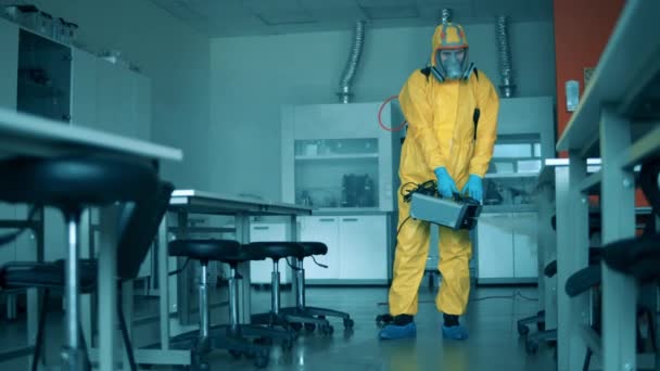 Άτομο απολυμαίνει εργαστηριακό δωμάτιο με ψεκαστήρα. — Αρχείο Βίντεο