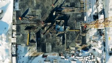 Üzerinde işçiler olan bir binanın tepesinden bak.