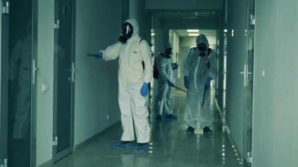 Skupina hygienických inspektorů dezinfikuje chodbu. Coronavirus, covid-19 koncept. — Stock video