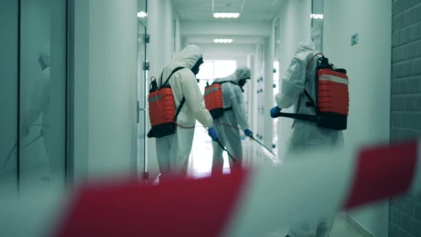 Grupo de desinfectantes están desinfectando un pasillo durante la pandemia de covid-19. Desinfección, concepto de saneamiento. — Vídeos de Stock