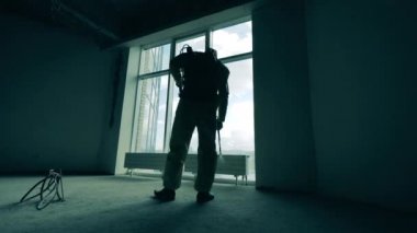 Boş odadaki pencere bir işçi tarafından dezenfekte ediliyor.