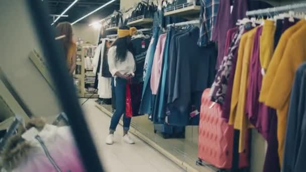 Senhoras alegres estão escolhendo roupas durante as compras — Vídeo de Stock