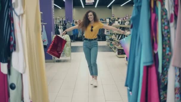 Loja de roupas com uma senhora alegre girando com sacos — Vídeo de Stock