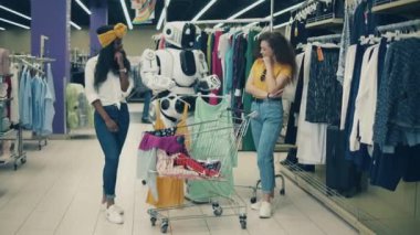 Genç kadınlara kıyafet sunan bir robotla giysi butiği.