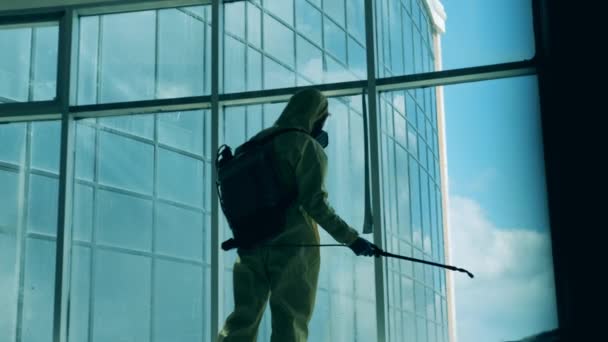 Sanitary specialist is disinfecting a large window in business center. Disinfection, sanitation concept. — Stock Video