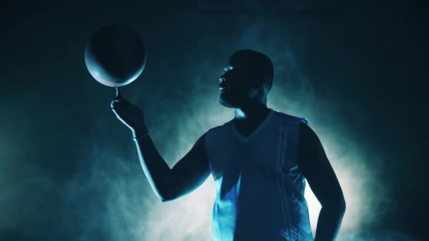 Deportista afroamericano está girando una pelota de baloncesto en su dedo — Vídeos de Stock