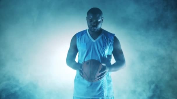 Jugador africano sostiene una pelota de baloncesto en las nubes de humo — Vídeos de Stock